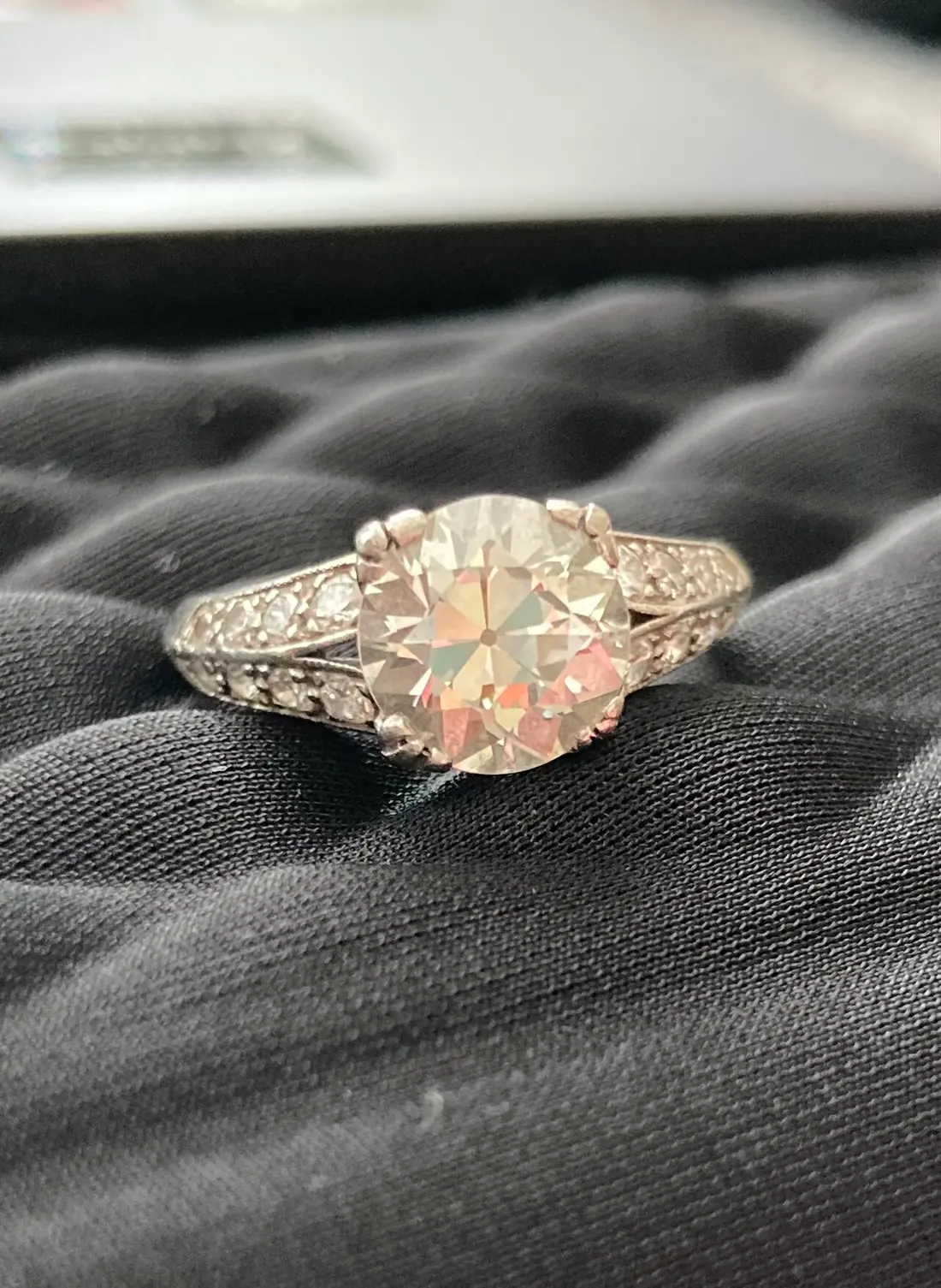 An Old European cut diamond in an Art Deco ring with pavé-set shoulders
