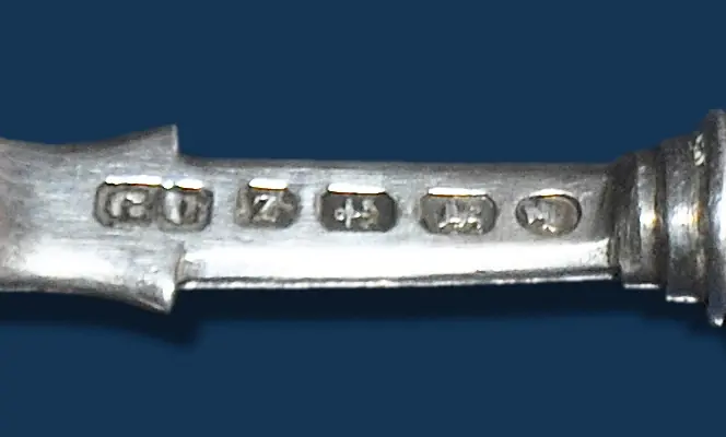 A row of six struck British hallmarks on the handle of a Victorian silver spoon
